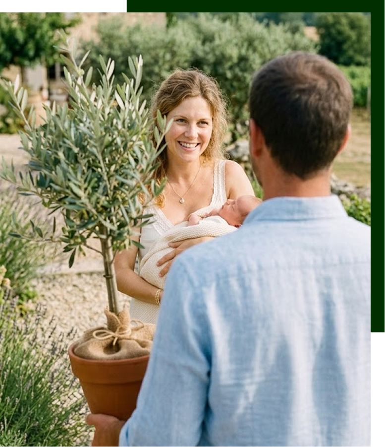 Un couple avec leur bébé recevant un olivier en pot dans un jardin de Provence